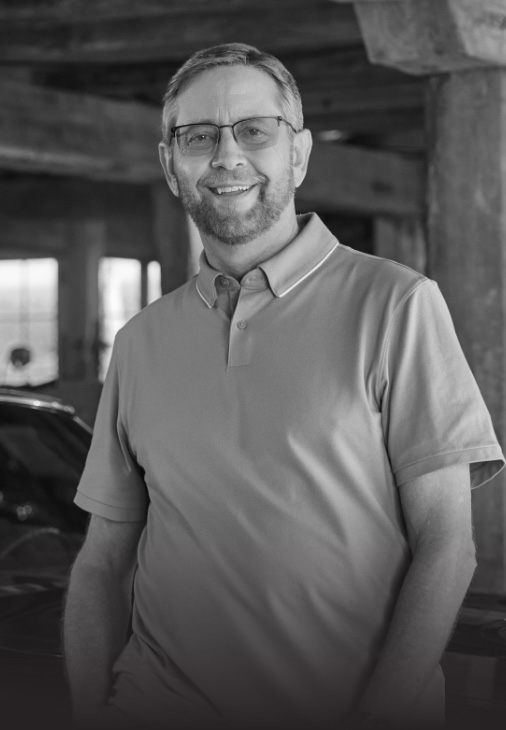 Ambassador Michael, who has LOPD, standing in a garage and smiling at the camera