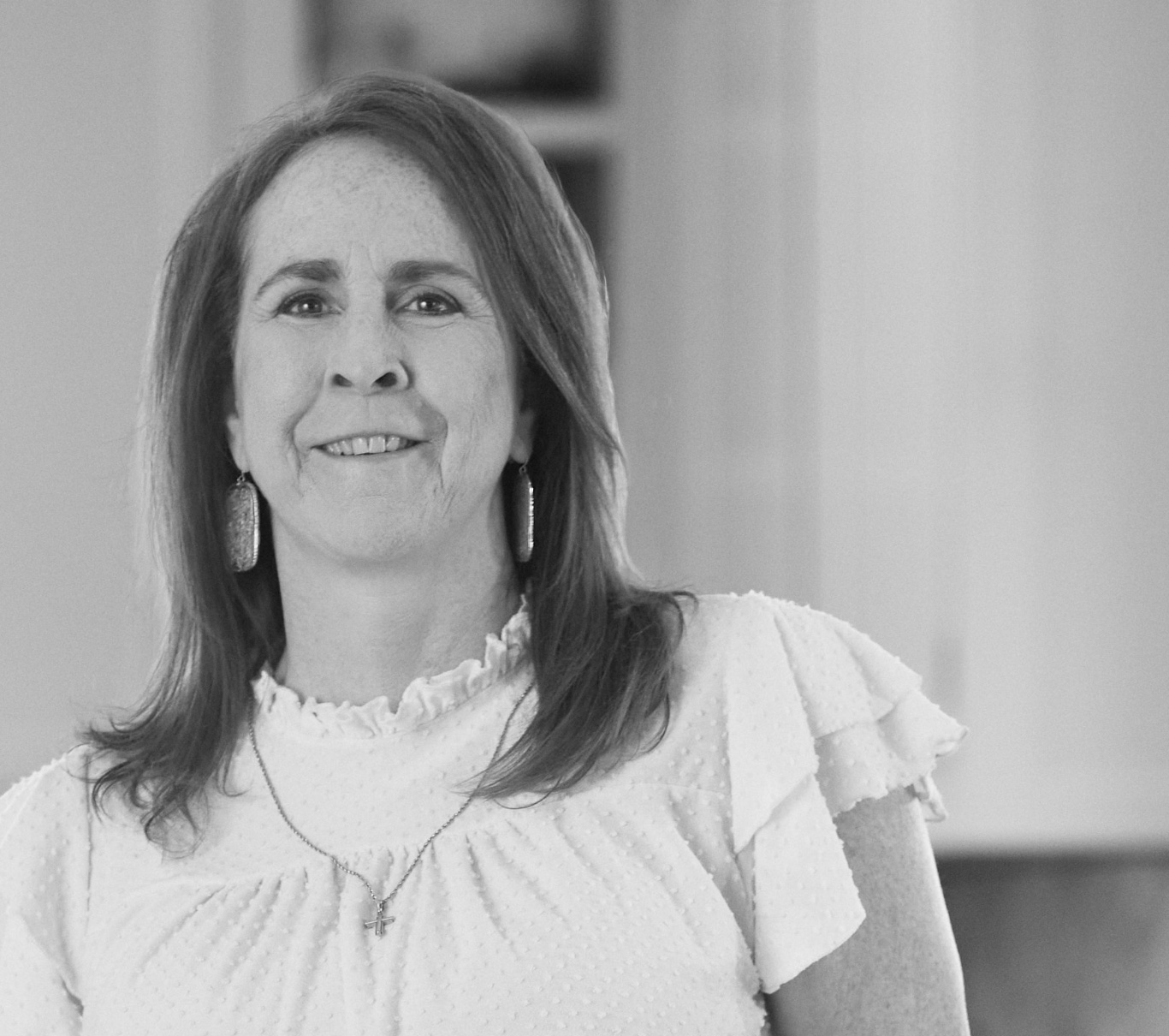 Ambassador Kerri, who has LOPD, standing in a kitchen and smiling at the camera
