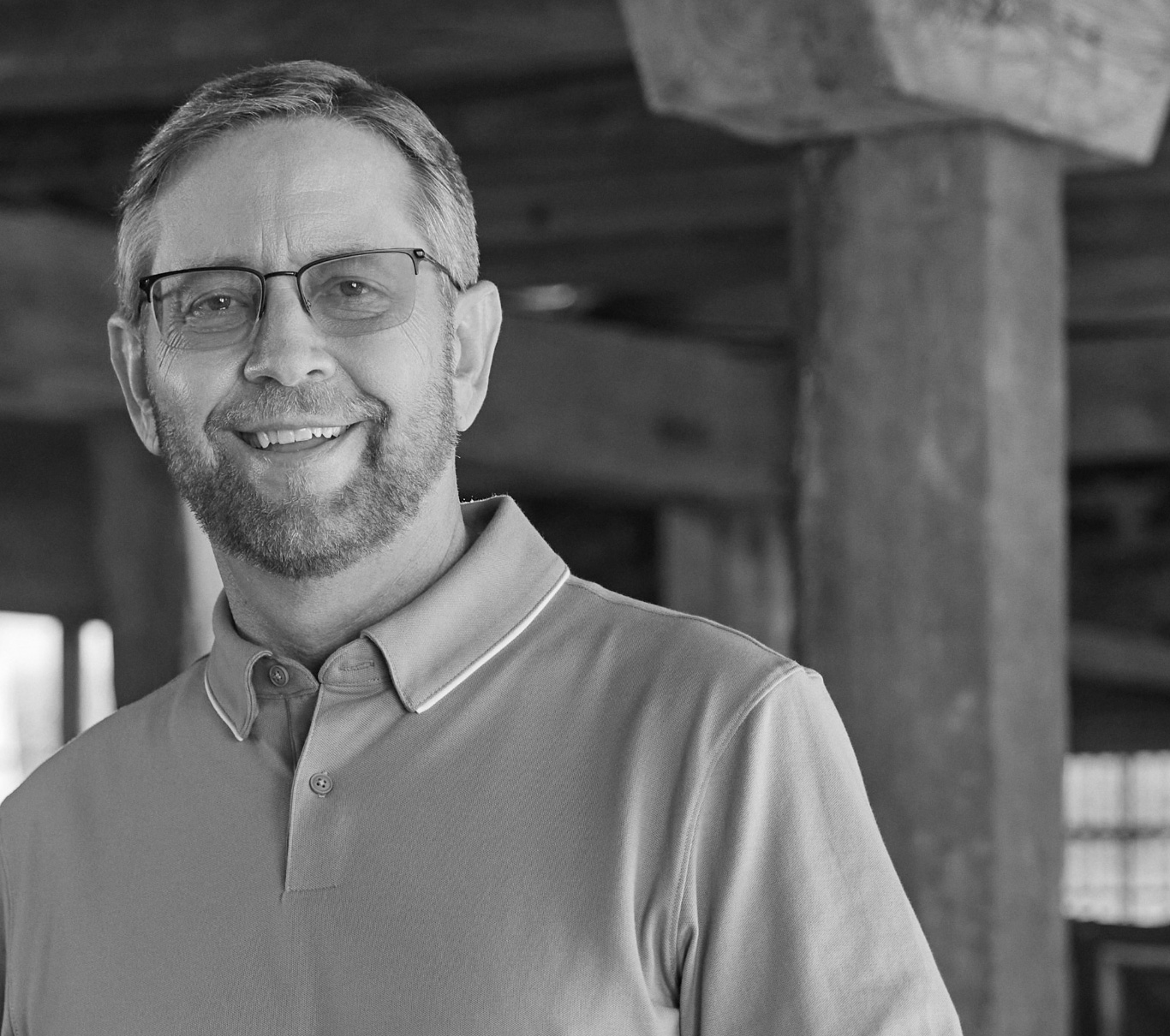 Ambassador Michael, who has LOPD, standing in a garage and smiling at the camera