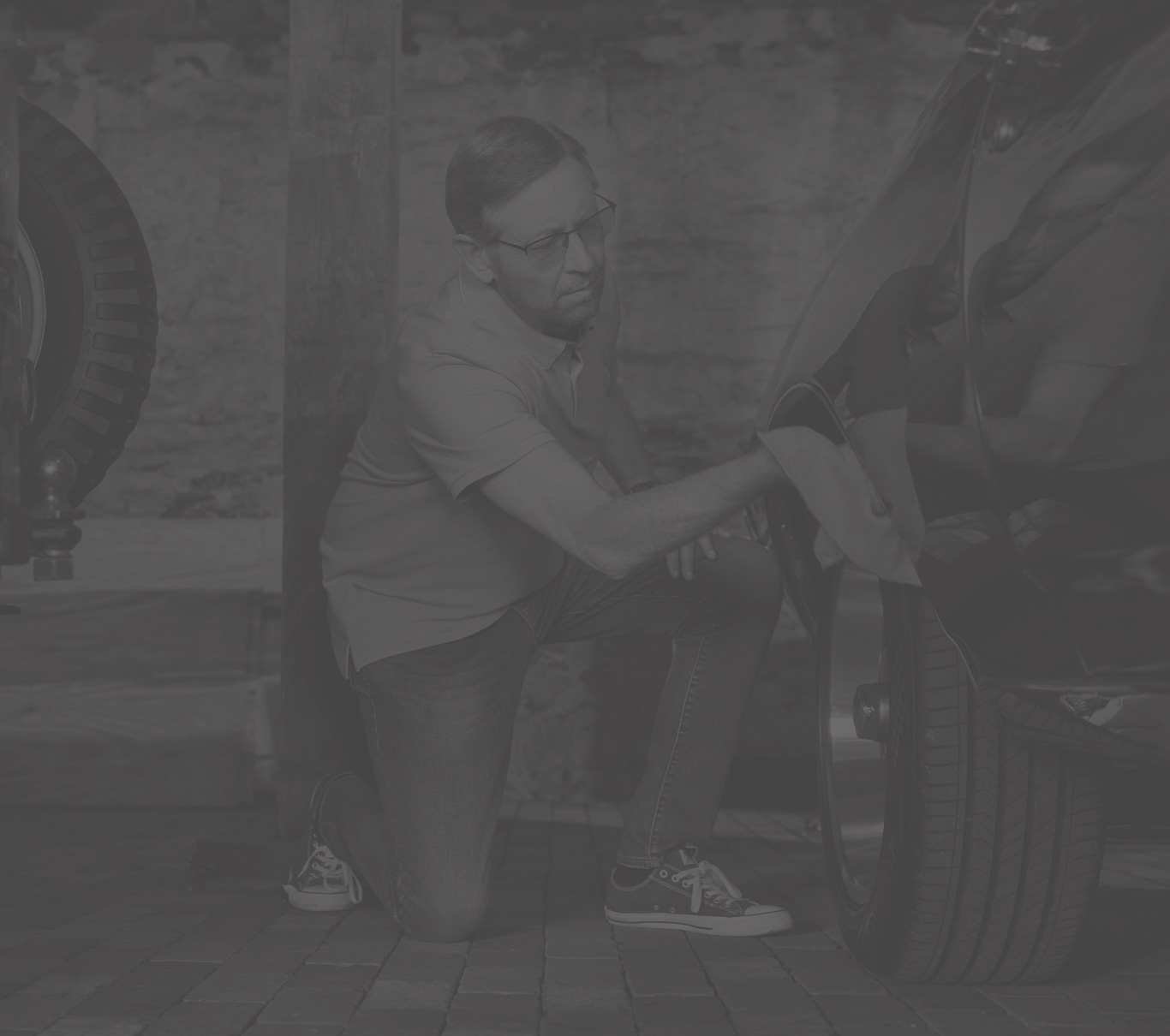 Ambassador Michael, who has LOPD, checking a car tire