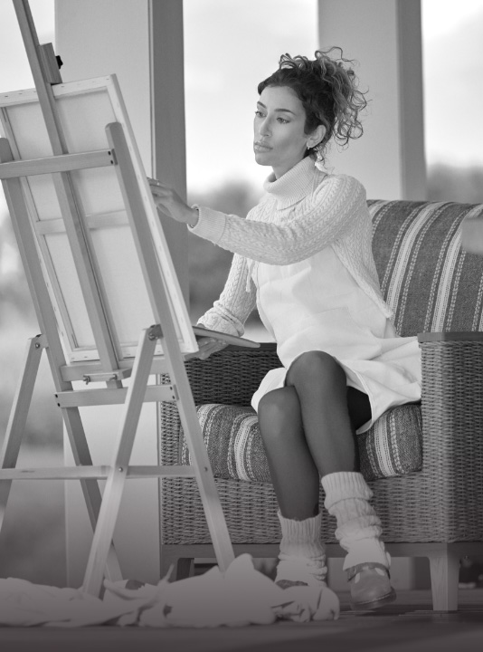 Ambassador Veronica, who has LOPD, sitting on a chair and painting